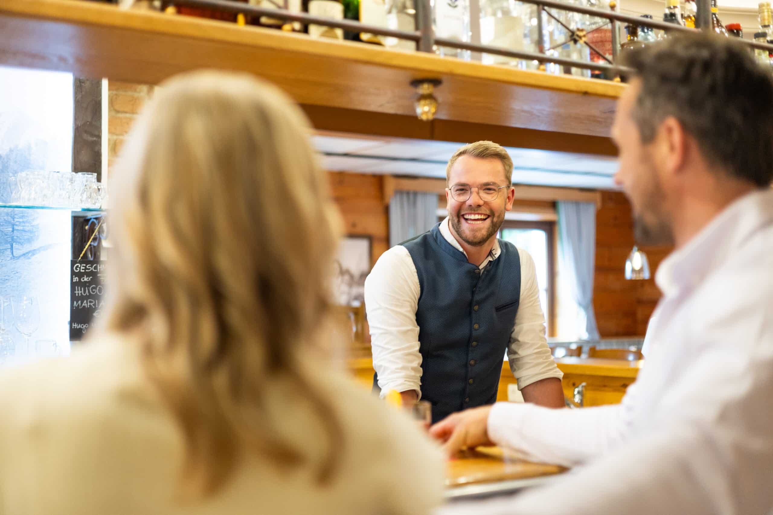 Bar_Bischofsmütze Final-3 Mitarbeiter spricht mit Gästen an der Bar