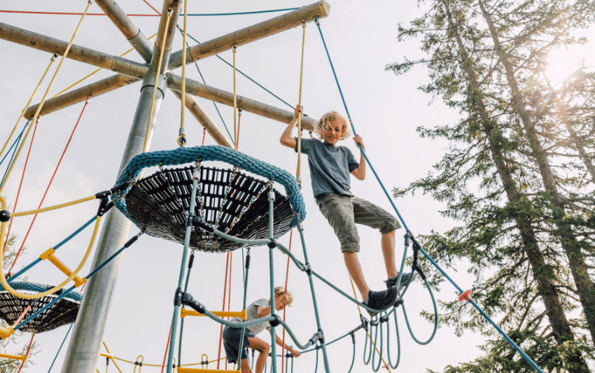 Salzburg Geisterberg Erlebniswelt Junge klettert auf Kletterspielplatz am Salzburger Geisterberg